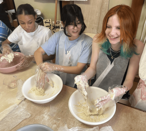 students laughing while making noodle dough