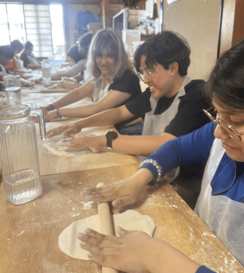 students roll out noodle dough 