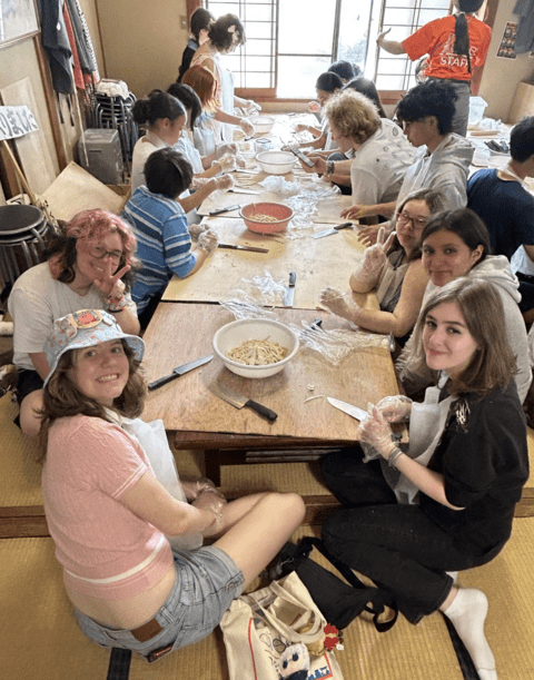 students smiling about to cut their noodle dough 