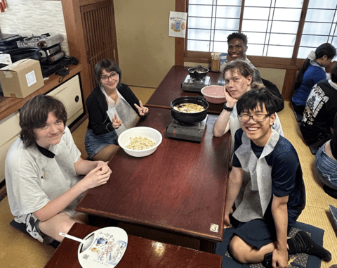 students smiling with their boiled noodles