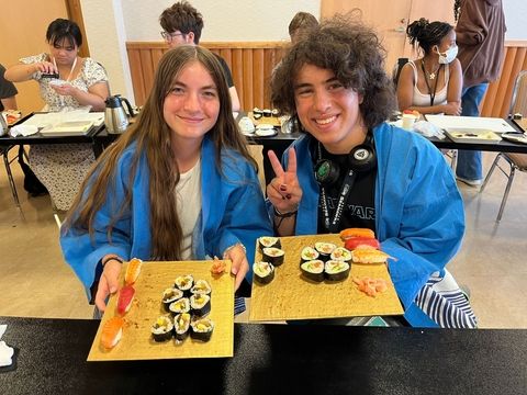 students posing with sushi they made on program in Japan