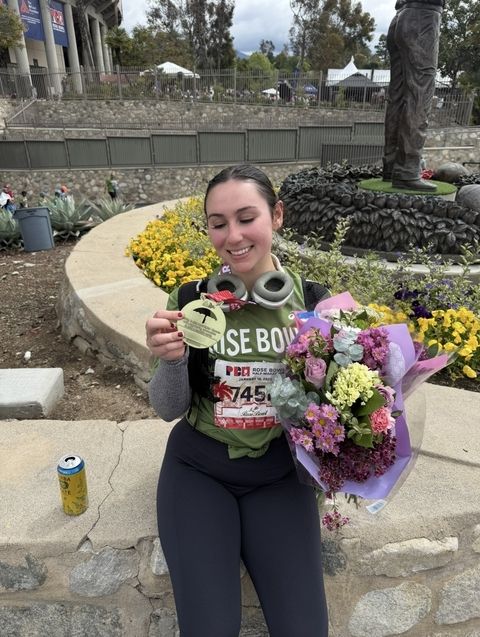 Woman holding medal and flowers after race