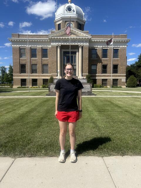 Hannah W. stands in front of her county's courthouse.