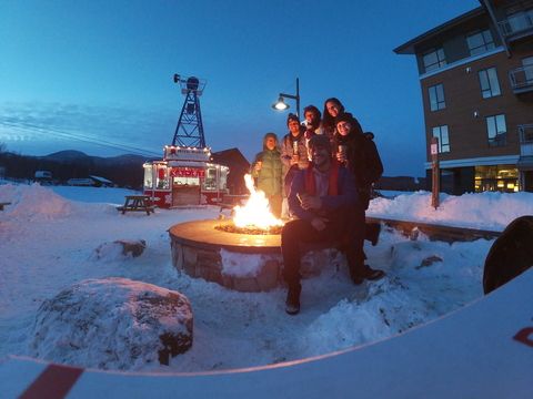 A BridgeUSA group warms up by an outdoor fire pit.