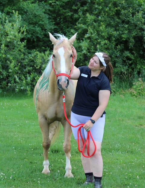 Venla S. pets one of the horses at the summer camp she worked at.