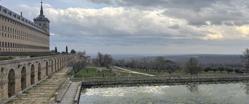 A landscape photo looking out over a lake with a stone pathway and ornate building to the left.