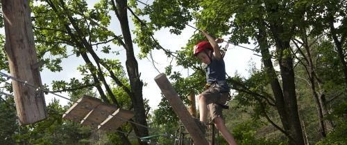 Kid at camp on an outdoor obstacle course