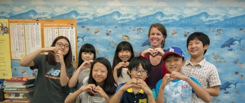 Teach in South Korea teacher and students making hearts with their hands