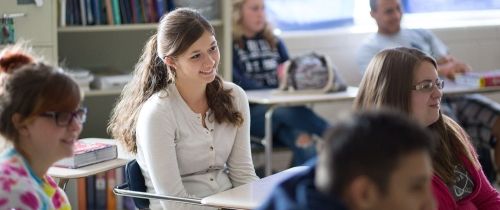 High school USA exchange student at desk in classroom