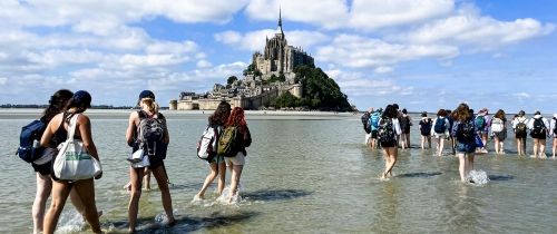 hssa rennes students walking in the low tide to mont st. michael
