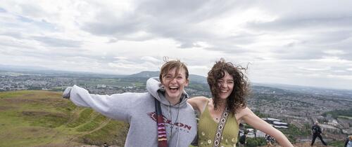 edinburgh_two-students-smile-on-top-of-arthurs-seat.jpg