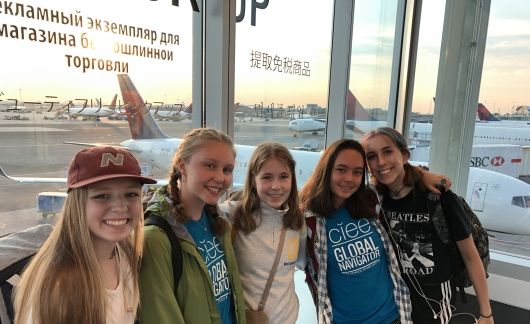 High school students in the airport taking a group selfie