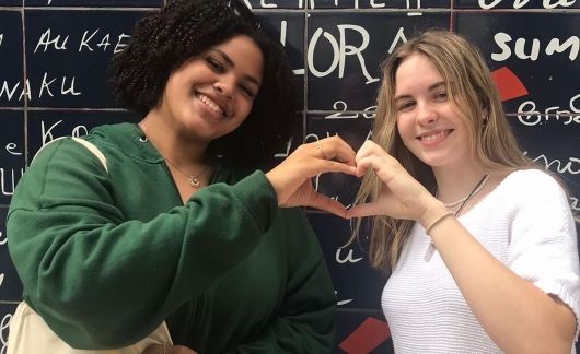 Two high school girls making a heart with their hands