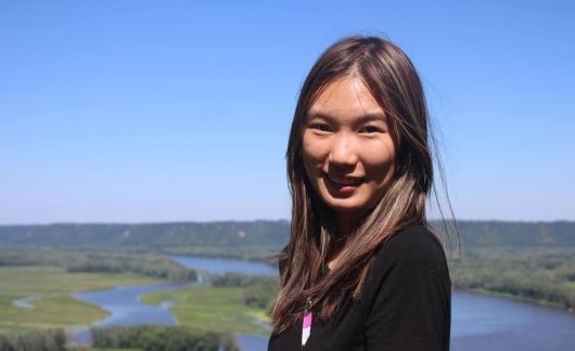 High school girl smiling with a river behind her