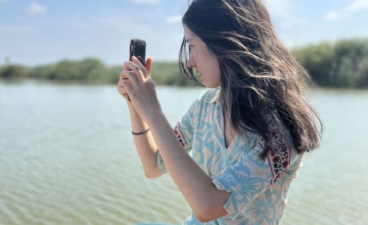 High school student on the water taking a photo