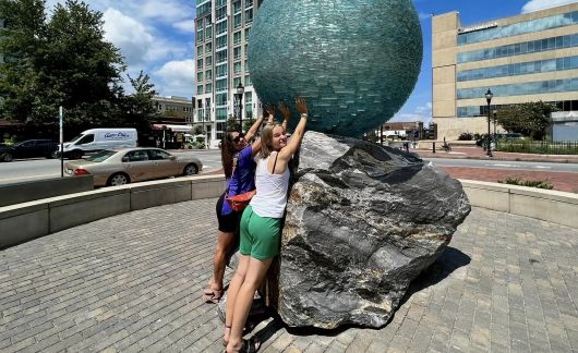 host mom and daughter with ball statue