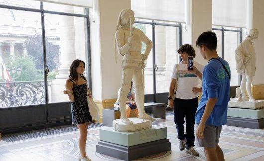 High school students posing with statue at Paris museum