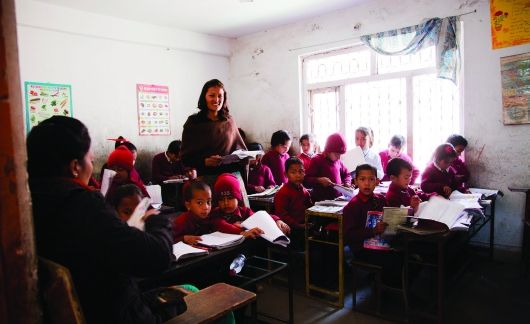 Students sitting at desk while teacher instructs them