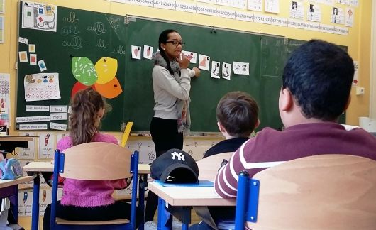 Teacher at front of class teaching students