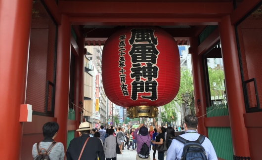 Giant red lantern hanging above crowd of people in Tokyo