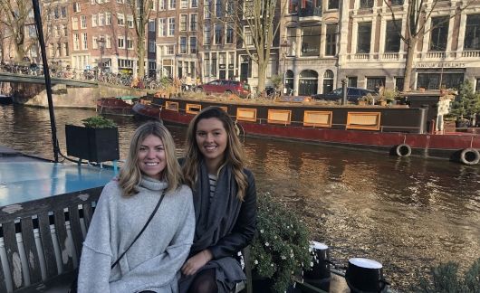 two students sitting by amsterdam canal