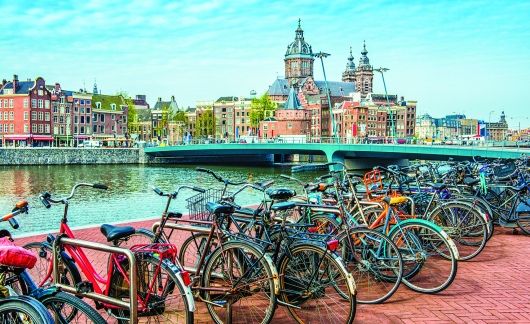 bikes along amsterdam canal sunny day