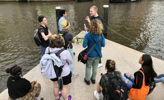 Students and instructor in discussion by the water in Amsterdam