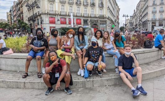 High school students sitting on the steps of Madrid Plaza