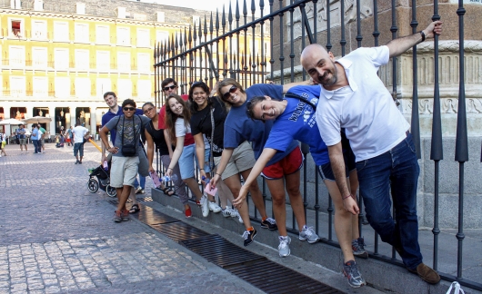 madrid students hanging off of a fence