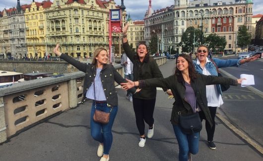 Prague girls on bridge with their hands out