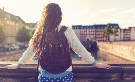 copenhagen girl with backpack looking out over canal