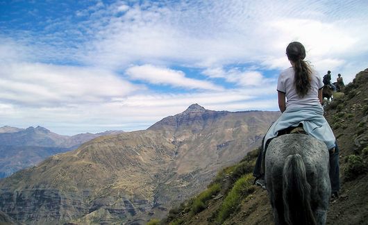 santiago ch girl riding a horse up a mountain side