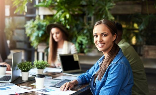young woman waving a working meeting at a coffeeshop with coworker