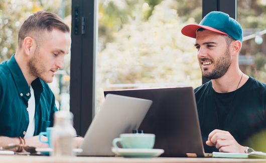 auckland two young men on laptops at long table