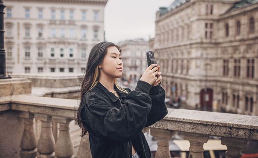 Young woman taking pictures while standing in Vienna, Austria