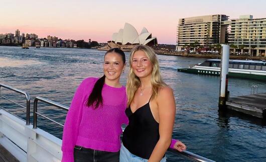 sydney-two-female-students-posing-boat-sydney-harbor-opera-house-background