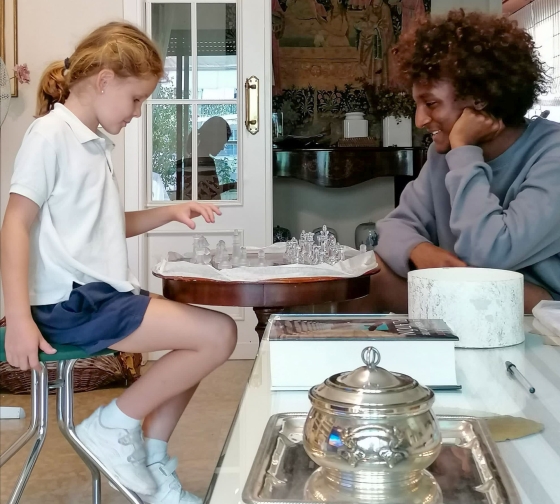 Seville student playing chess with host family's granddaughter