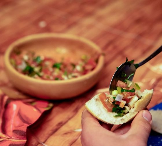 santiago ch student putting salsa on a piece of bread