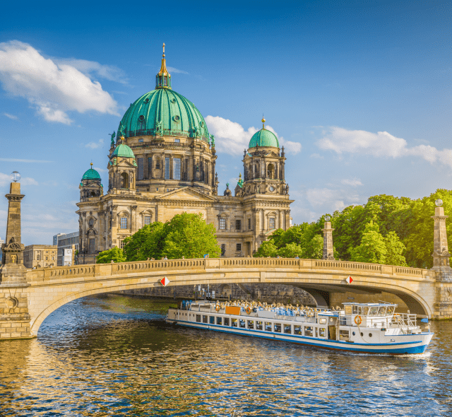 Berlin Cathedral with boat going under bridge.