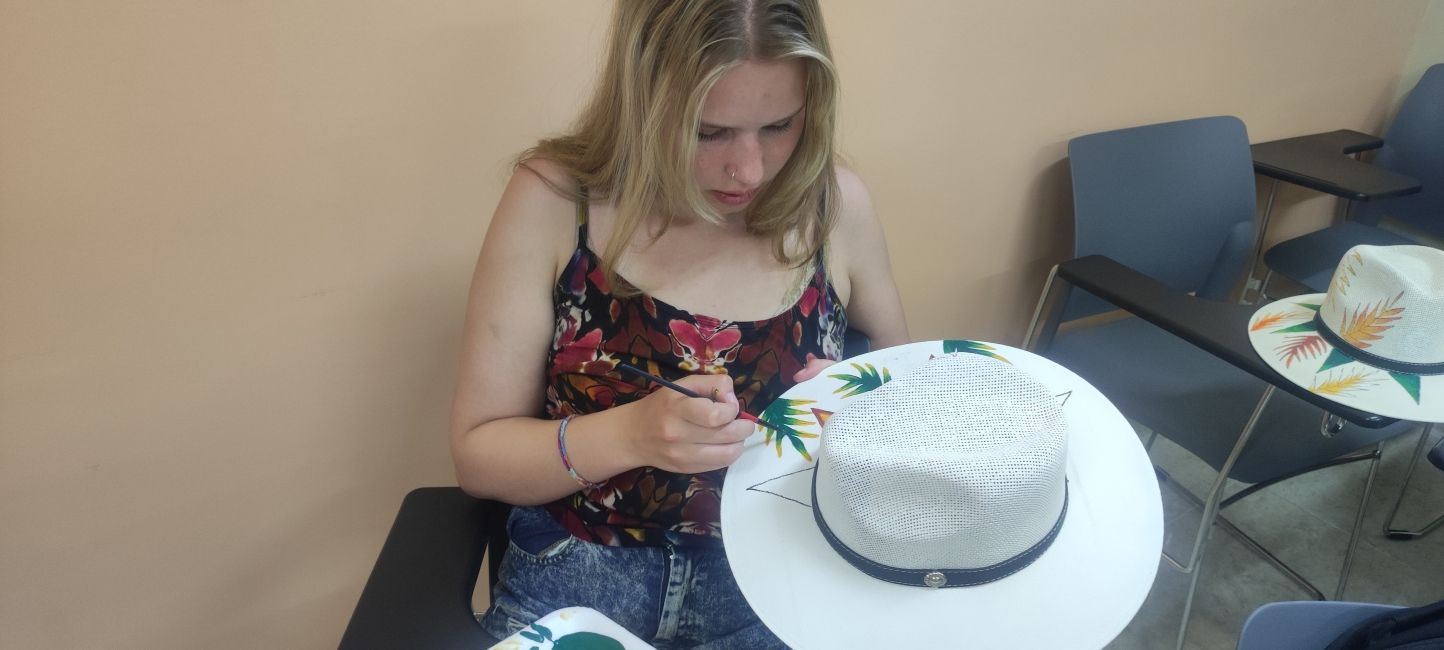 Student painting a hat