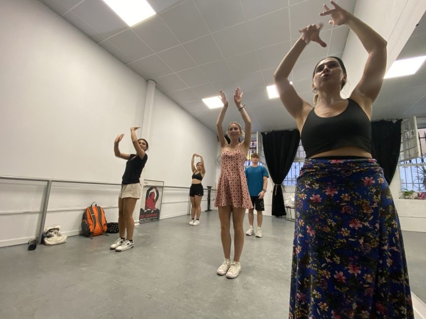 Students learning how to move their hands according to the dance