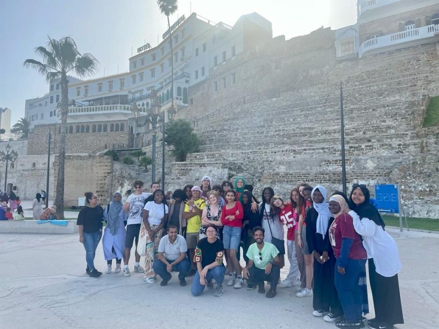 Students posing for picture in front of the Old Medina's stone walls in Tangier.