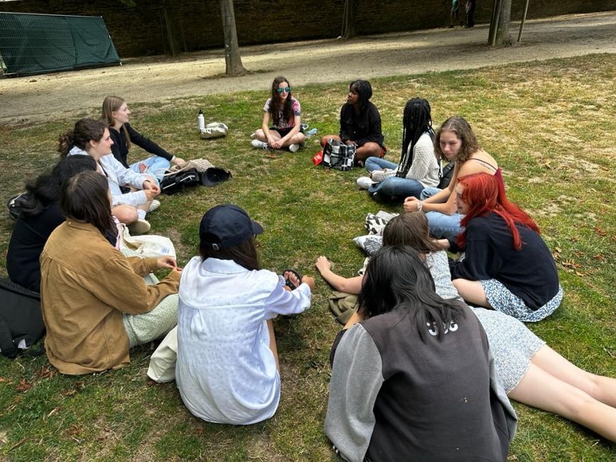 Students sitting in a circle on the grass