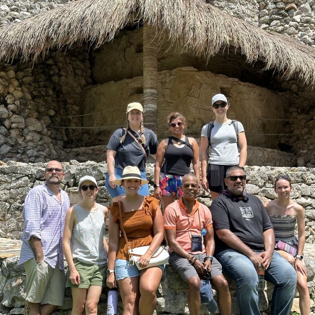 Photo of 9 people in front of ruins