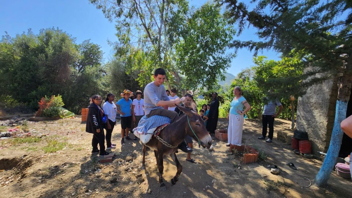 A CIEE student riding a donkey at a rural home in northern Morocco