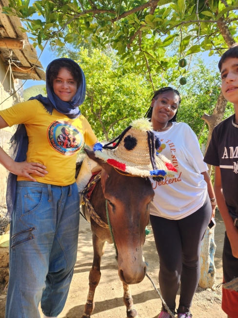 Marly and Ja'Niya posing with the family donkey
