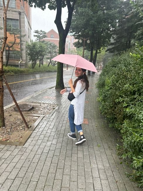 Subject walking in the rain with a pink umbrella