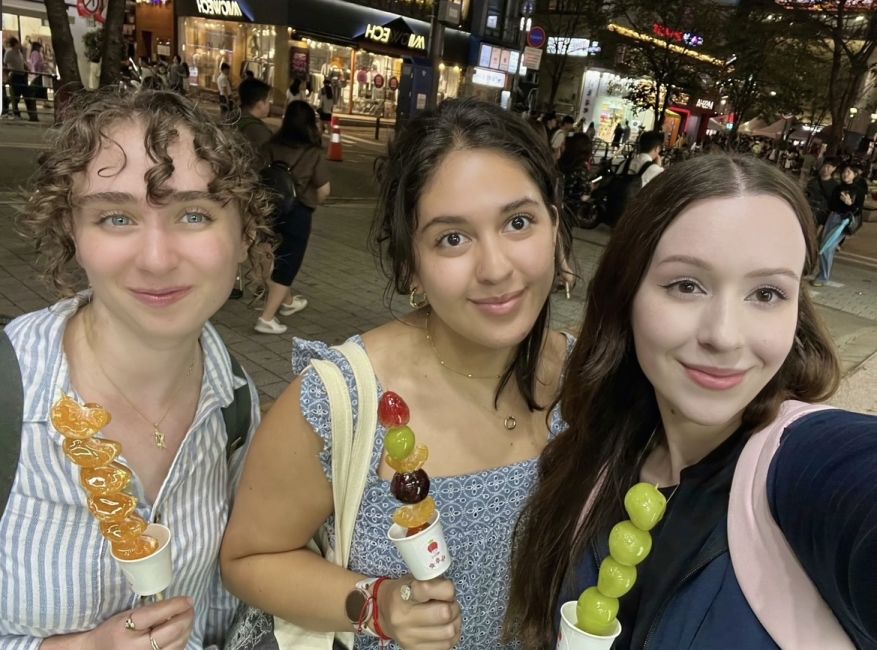 Us CIEE besties enjoying a street food called "Tanghulu" which is fruit on a stick that has been candied so the outside is crunchy.