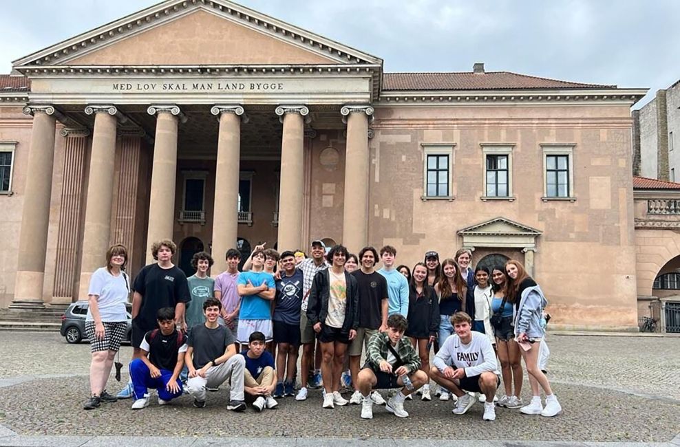 High school students posing in front of columned building