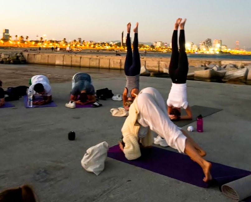 Students practicing yoga in Barcelona at sunset